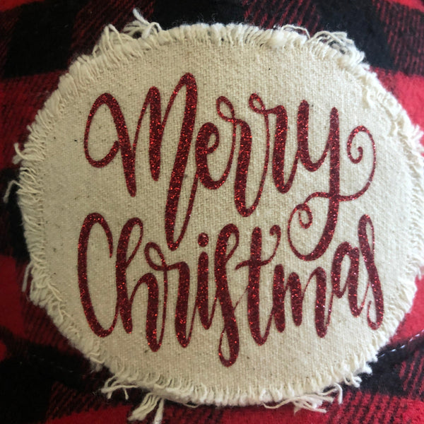 Round embroidered patch with 'Merry Christmas' text on a red and black plaid fabric background.