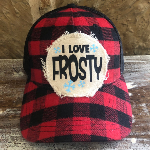 Red and black checkered cap with 'I Love Frosty' patch on a wooden surface.