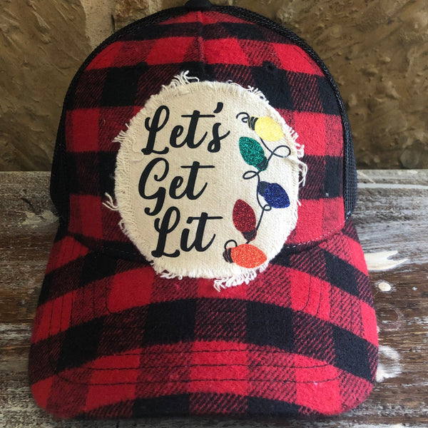 Red and black plaid cap with 'Let's Get Lit' patch on a wooden surface