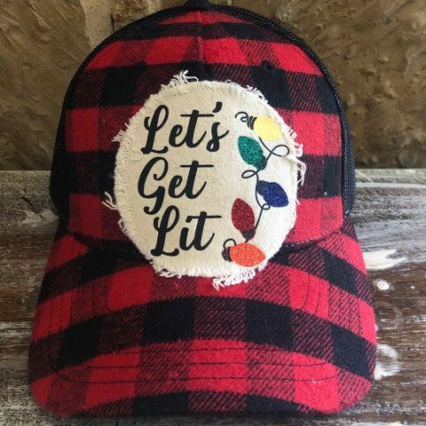 Red and black plaid cap with 'Let's Get Lit' patch on a wooden surface