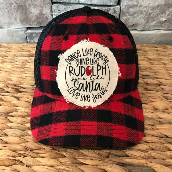 Red and black plaid cap with a white circular patch on a woven surface-rudolph
