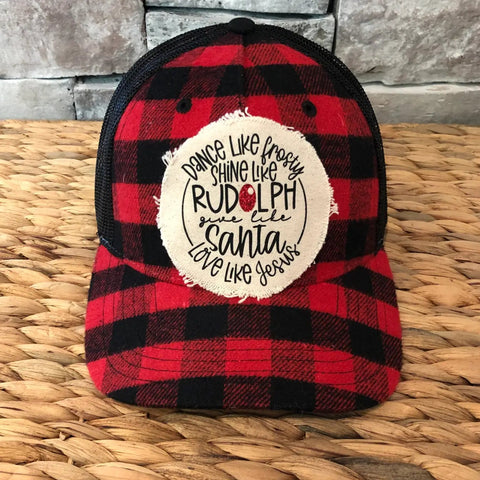Red and black plaid cap with a white circular patch on a woven surface-rudolph