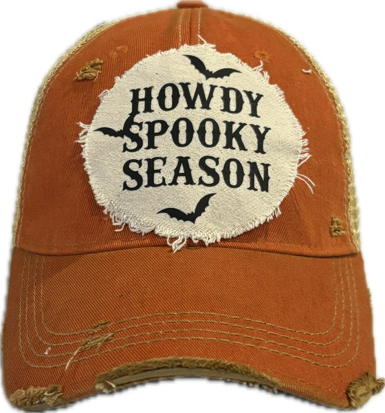 A vintage-inspired orange baseball hat with 'HOWDY  SPOOKY SEASON' text and bat graphics on the front.