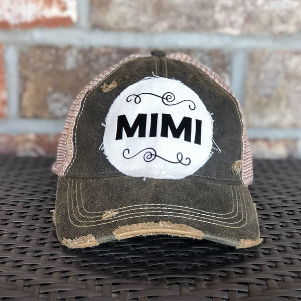 A distressed black baseball cap with an oversized white 'MiMi' logo on the front.