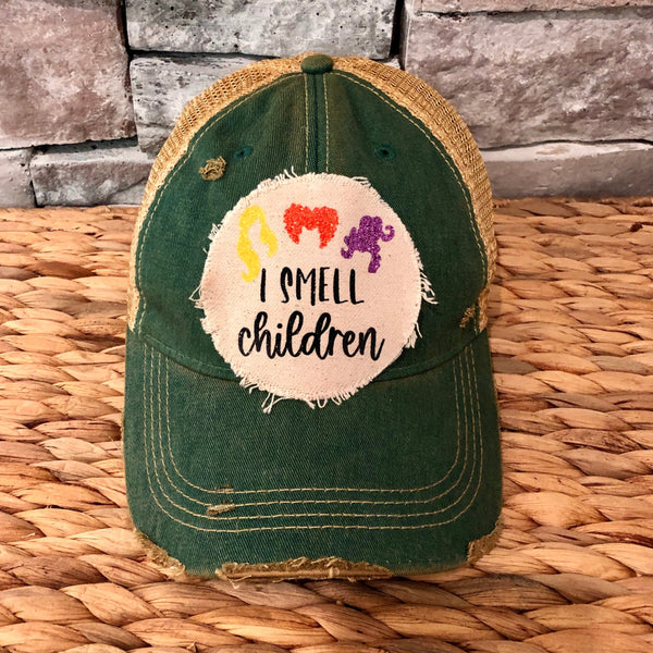 A green distressed vintage-style baseball hat with 'I SMELL CHILDREN' text on it